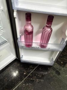 two glass bottles are sitting inside of a refrigerator at Lara Homestay 1bhk Begumpet in Hyderabad