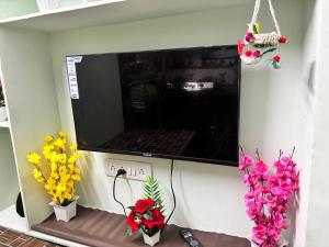 a room with flowers and a tv on a wall at Lara Homestay 1bhk Begumpet in Hyderabad