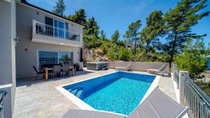 a swimming pool in front of a house at Villa Antonia by Villas Guide in Blato