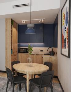 a dining room table with chairs and a blue kitchen at Cobalt36 in Bolesławiec +12 photos