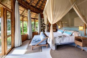 a bedroom with a bed in a room with windows at Thonga Beach Lodge in Mabibi +41 photos