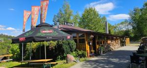 a restaurant with an umbrella in front of it at Domki & Jacuzzi w Centrum Soliny 885-053-839 in Solina