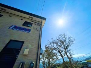 a building with a blue sign on the side of it at あざみ庵 屋久島 in Yakushima
