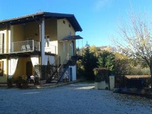 a house with a balcony and stairs on it at La Casa Gialla in Monforte dʼAlba
