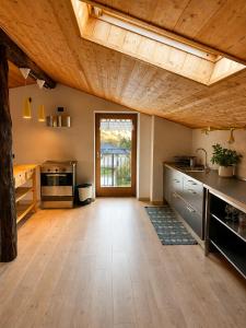 a large kitchen with wooden ceilings and a wooden floor at Mansarda Ossana in Fucine