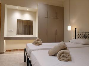 a bedroom with two beds with towels on them at Ktima Kallitero Villas in Argassi +59 photos
