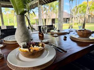 a wooden table with a bowl of food on it at Life is One in Uluwatu +62 photos