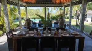 a wooden table with plates and dishes on it in a restaurant at Life is One in Uluwatu