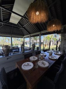 a dining room with a wooden table and chairs at Life is One in Uluwatu