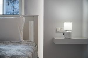 a bedroom with a bed with a pillow and a lamp at Minimal Stay House in Petalidi