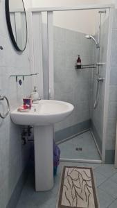a bathroom with a sink and a shower with a mirror at Appartamento Patty in Cannole +18 photos