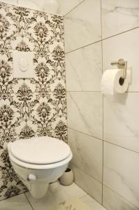 a bathroom with a toilet and a wall at In-N-Out Ilica in Zagreb