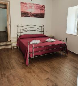a bedroom with a bed with a red bedspread at Dimora Visconti in San Demetrio neʼ Vestini
