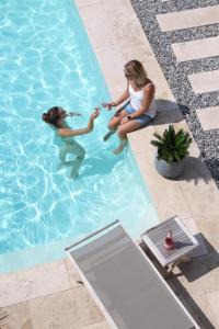 two girls are playing in a swimming pool at Ferienwohnung Königshofer in Neusiedl am See