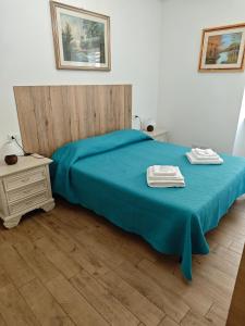 a bedroom with a blue bed with two towels on it at Dimora Visconti in San Demetrio neʼ Vestini