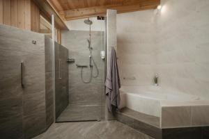 a bathroom with a shower and a bath tub at Lehner Schlössl in Leutasch +16 photos