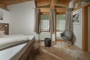 a bedroom with a bed and a chair and a window at Lehner Schlössl in Leutasch