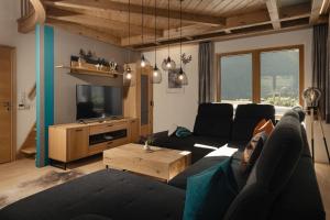 a living room with a couch and a tv at Lehner Schlössl in Leutasch