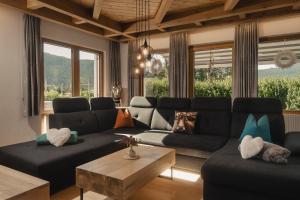 a living room with a black couch and a table at Lehner Schlössl in Leutasch
