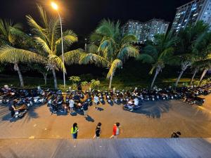 a crowd of people sitting on motorcycles on a beach at night at Bis Hotel Hồ Chí Minh in Chợ Phước Hải