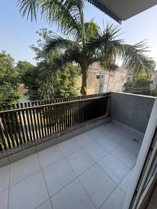 a balcony with a fence and a palm tree at Hotel Venezia Grand in Gurgaon