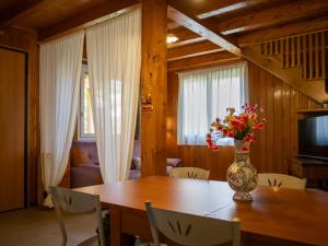 a dining room table with a vase of flowers on it at Giardino Carya - Giarre Centro in Giarre