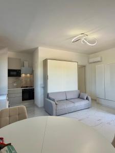ein Wohnzimmer mit Sofa und eine Küche in der Unterkunft PoliHome in Monserrato