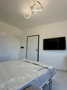 ein Schlafzimmer mit Bett und Flachbildfernseher in der Unterkunft PoliHome in Monserrato