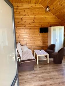 a room with a bed and a chair and a table at Zacisze Za Lasem in Jarosławiec