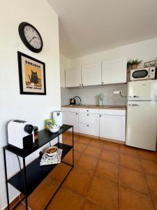 a kitchen with a white refrigerator and a clock on the wall at Holiday Village 8C in Senec +13 photos