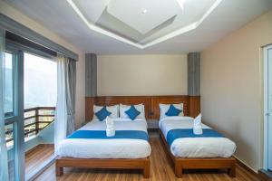 a bedroom with two beds and a balcony at Himalaya Forest Resort in Deorāli