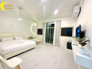 a white bedroom with a bed and a chair at Seoul House นครสวรรค์ in Sathani Pak Nam Pho
