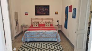 a bedroom with a bed with red pillows on it at Appartamento Patty in Cannole