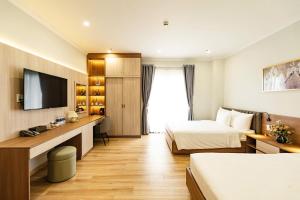 a hotel room with two beds and a television at Khach san Binh Ha in Quy Nhon