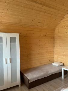 a bed in a room with a wooden ceiling at Zacisze Za Lasem in Jarosławiec