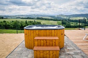 a large wooden hot tub sitting on a deck at Maruszyna Resort & SPA in Zakopane