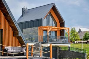 a house with a deck and a balcony at Maruszyna Resort & SPA in Zakopane