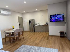 a living room with a table and a kitchen at Studio Liv in Sorriso +11 photos