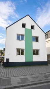 a white building with a green corner at NEU! Fly & Stay Residence Frankfurt Airport Kelsterbach in Kelsterbach