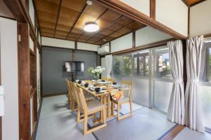 a dining room with a table and chairs and windows at オーシャンステイみうら in Miura