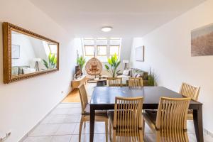 a dining room with a table and chairs and a mirror at Gellerico Apartments Wesselényi Street in Budapest