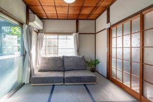 a couch in a room with a window at オーシャンステイみうら in Miura