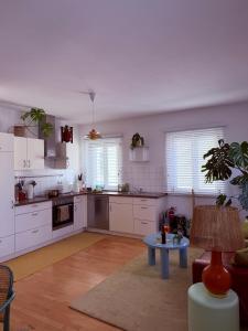 a kitchen with white cabinets and a table in a room at Apartment Luk - Design trifft Zuhause in Furth im Wald