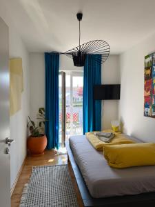 a bedroom with a large bed with blue curtains at Apartment Luk - Design trifft Zuhause in Furth im Wald