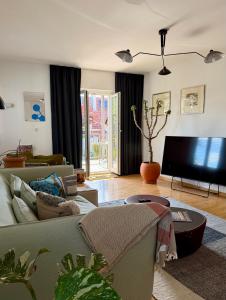 a living room with a couch and a flat screen tv at Apartment Luk - Design trifft Zuhause in Furth im Wald