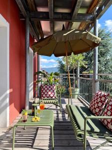 a porch with two chairs and an umbrella at Apartment Luk - Design trifft Zuhause in Furth im Wald