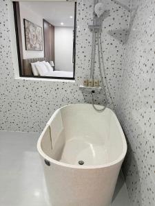 a white bath tub in a bathroom with a mirror at Minh Hai Hotel Lao Bao in Lao Bao +14 photos