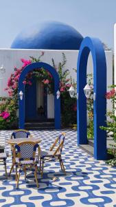 a patio with two chairs and a blue door at Greece In Blue in Kandivalli