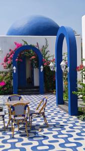 a patio with two benches and an arch with flowers at Greece In Blue in Kandivalli +34 photos