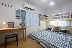 a bedroom with a bed and a desk and bunk beds at Tokyo Candle house in Tokyo